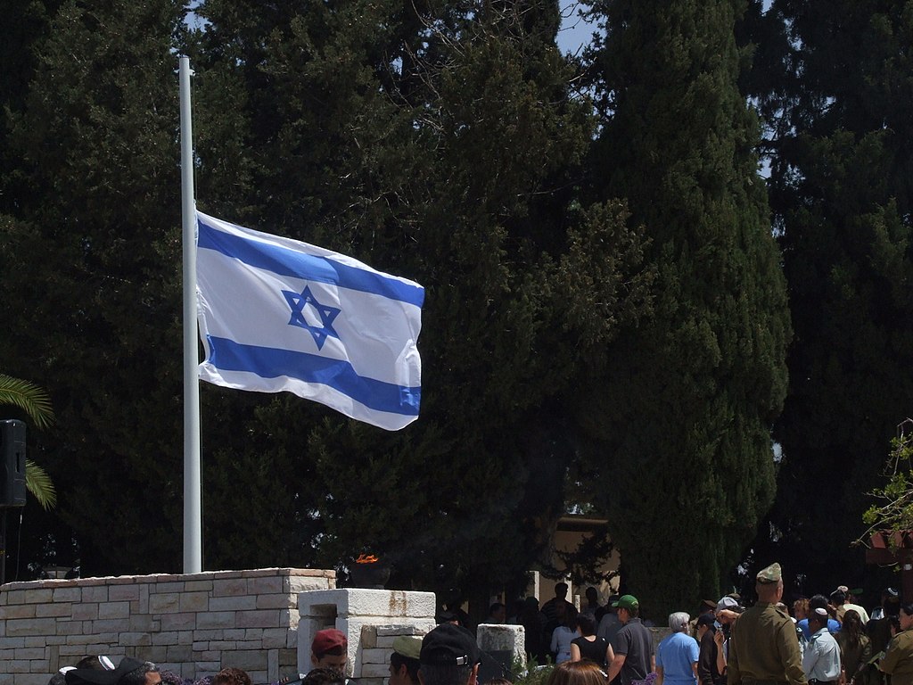 bandeira de Israel a meio mastro em um cemitério militar.