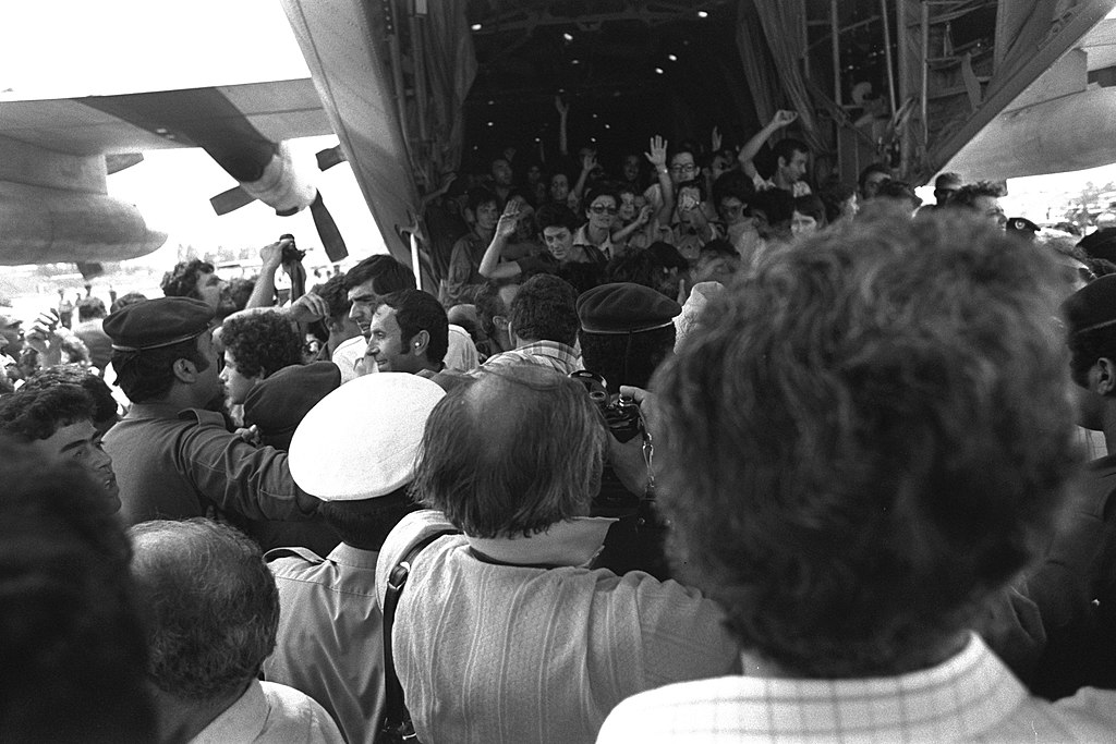 Legenda da foto: A recepção aos passageiros resgatados do sequestro do avião da Air France acenam para a multidão enquanto deixam o avião de transporte Hércules no aeroporto Ben Gurion.