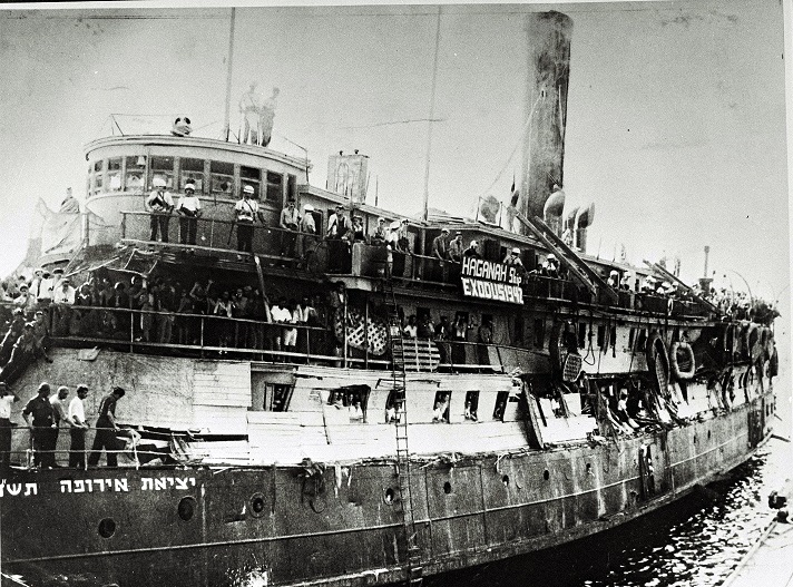Navio Exodus após a apreensão dos ingleses (observe os danos às barreiras improvisadas). O banner diz: "HAGANAH Ship EXODUS 1947".